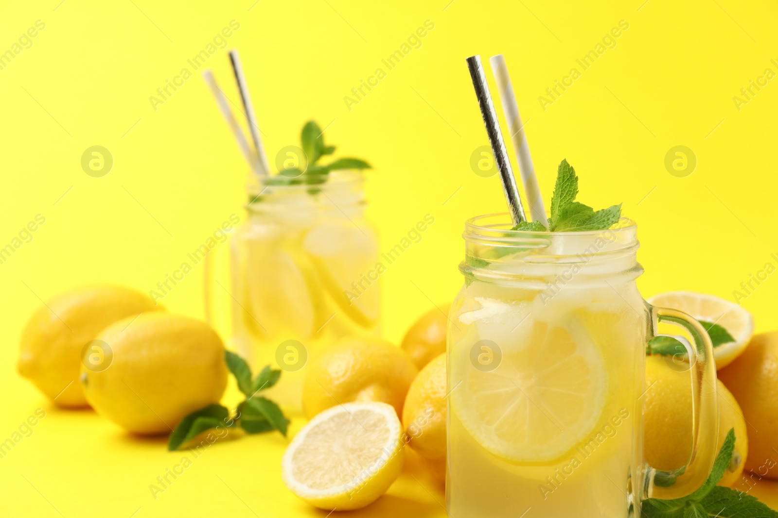 Photo of Natural freshly made lemonade with mint on yellow background, closeup. Summer refreshing drink