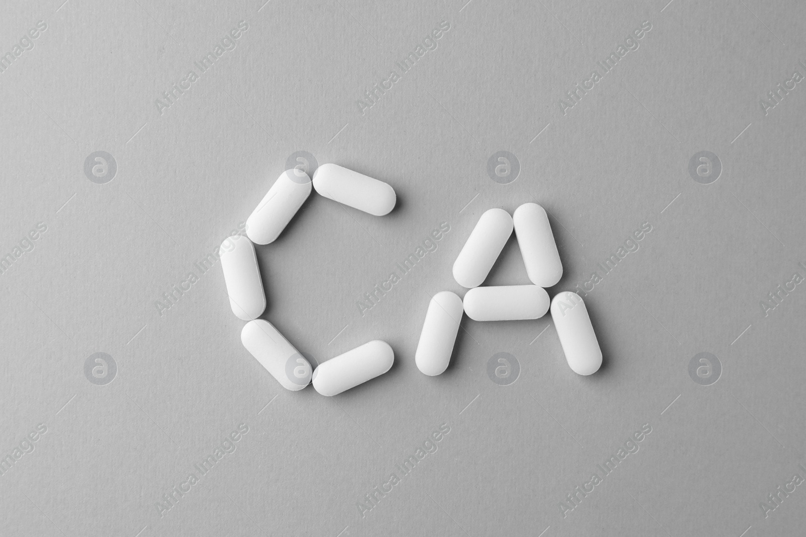 Photo of Calcium supplement pills on light grey background, flat lay