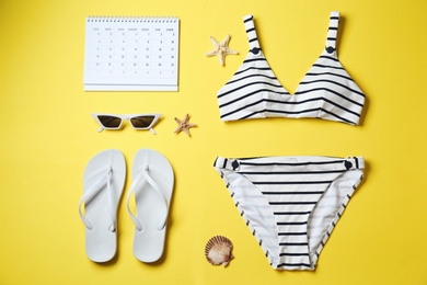 Photo of Flat lay composition with beach objects on yellow background
