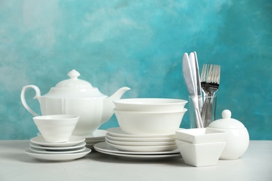 Set of clean dishes on table against blurred background