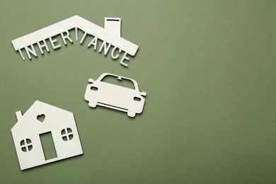 Photo of Word Inheritance, car and house models on green background, flat lay. Space for text