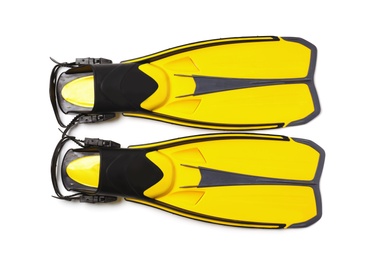 Pair of yellow flippers on white background, top view