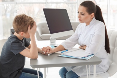 Photo of Little boy having appointment at child psychologist office