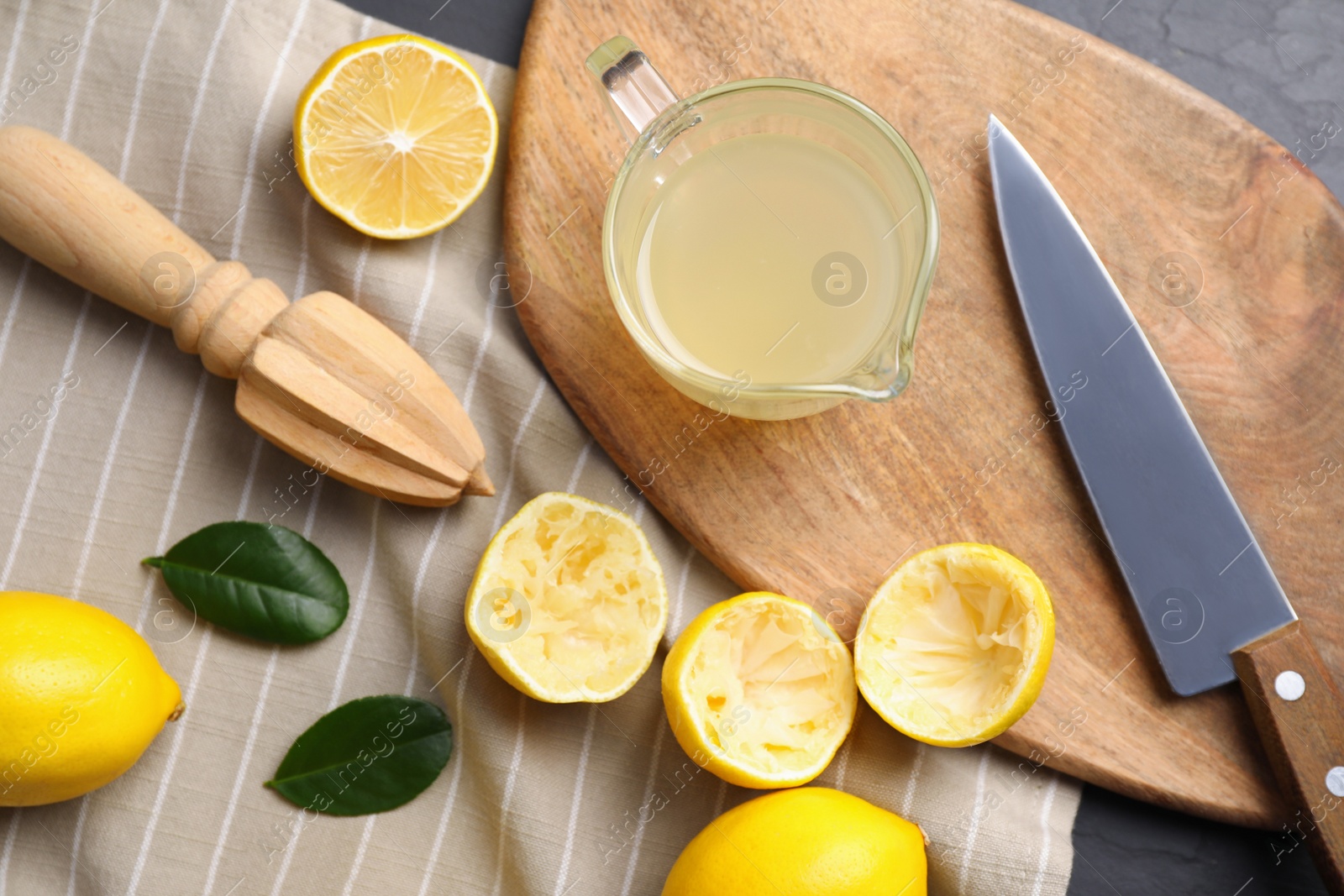 Photo of Flat lay composition with freshly squeezed lemon juice on table
