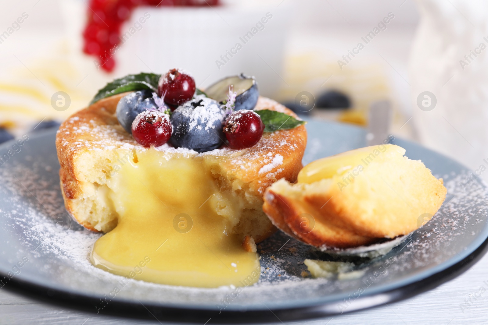 Photo of Tasty vanilla fondant with white chocolate and berries on table, closeup