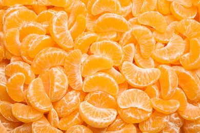 Fresh juicy tangerine segments as background, top view