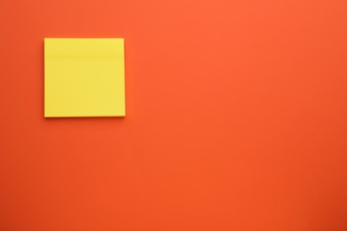 Photo of Paper note on orange background, top view. Space for text