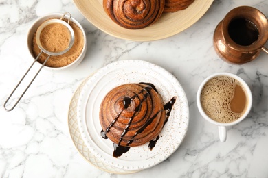 Flat lay composition with freshly baked cinnamon roll on marble background