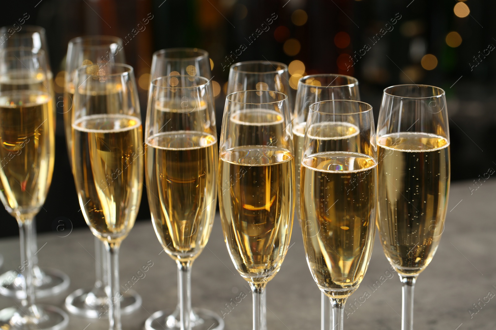 Photo of Many glasses of champagne on blurred background, closeup