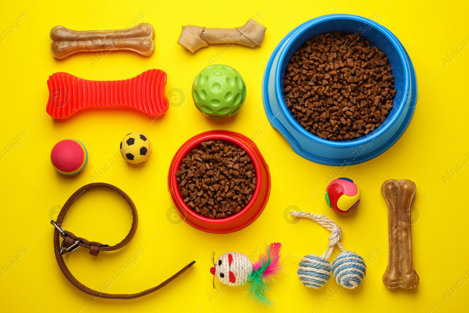 Photo of Flat lay composition with pet toys and feeding bowl on yellow background