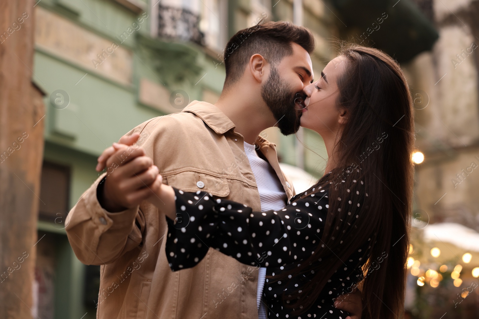 Photo of Lovely couple kissing and dancing together on city street