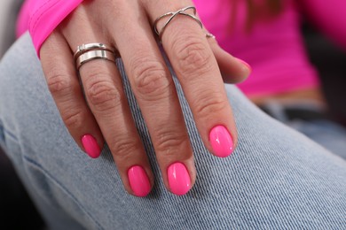 Photo of Woman showing manicured hand with pink nail polish, closeup