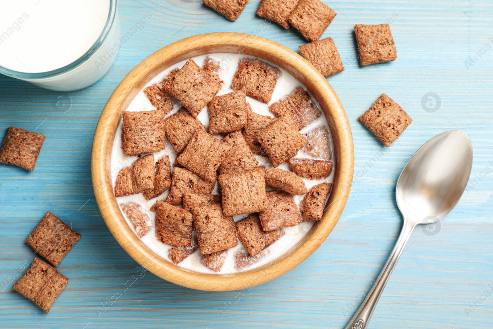 Photo of Bowl with tasty corn pads and milk on turquoise wooden table, flat lay