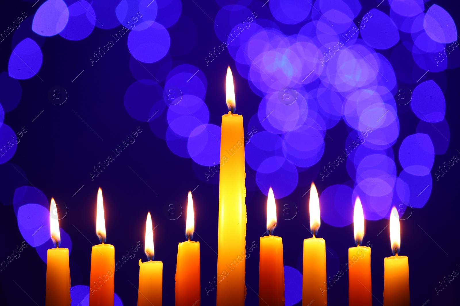 Photo of Hanukkah celebration. Burning candles against blurred lights