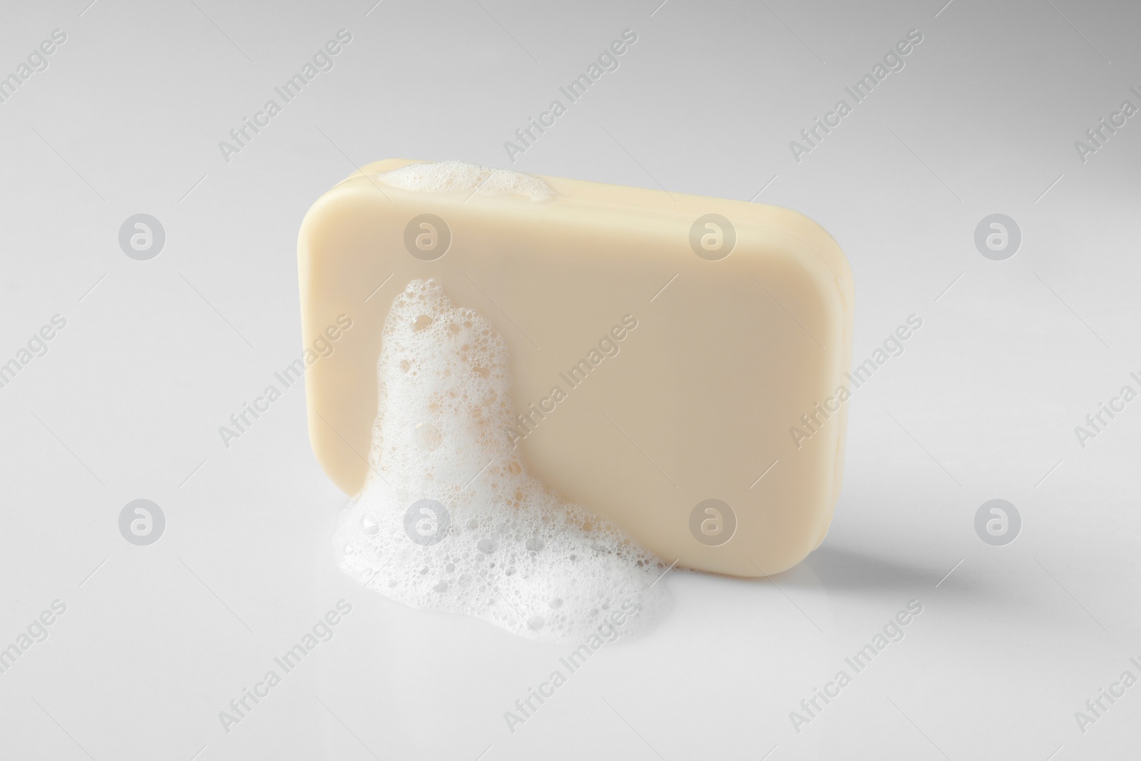 Photo of Soap with fluffy foam on white background