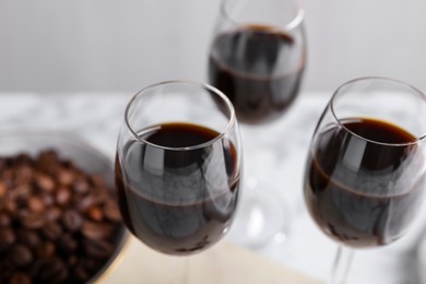Photo of Glasses of coffee liqueur on blurred background, closeup