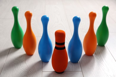 Photo of Fabric bowling pin among others on wooden floor. Diversity concept