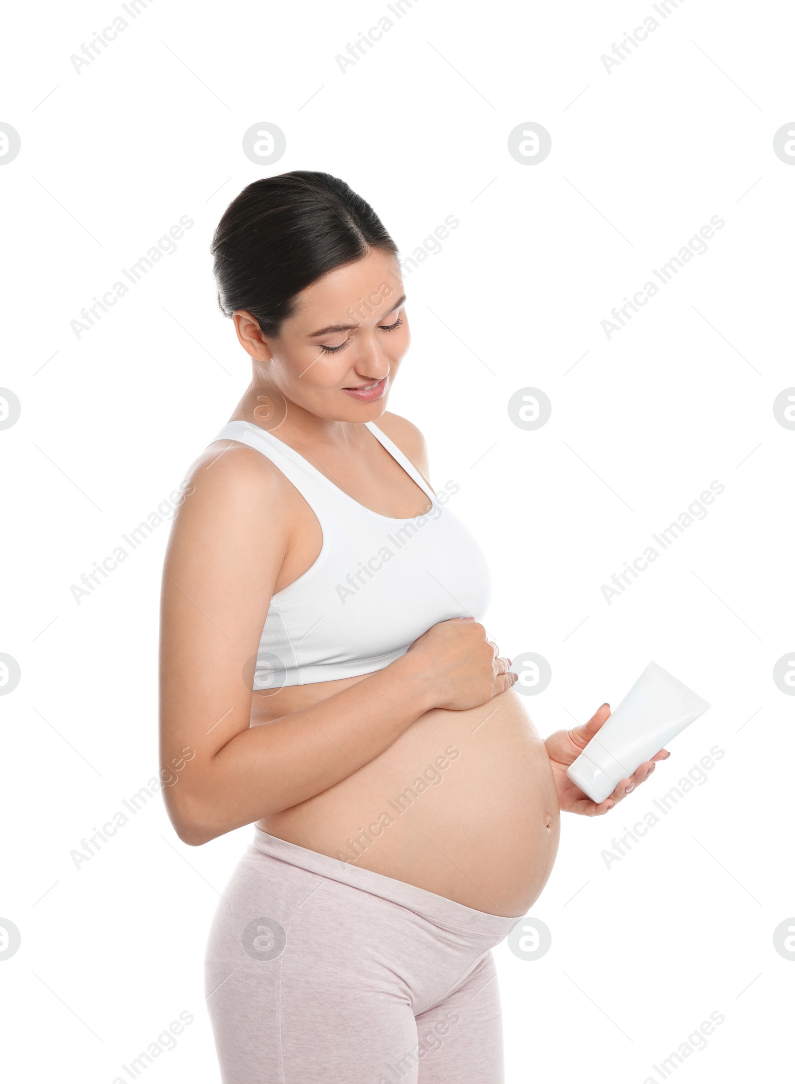 Photo of Pregnant woman holding body cream on white background