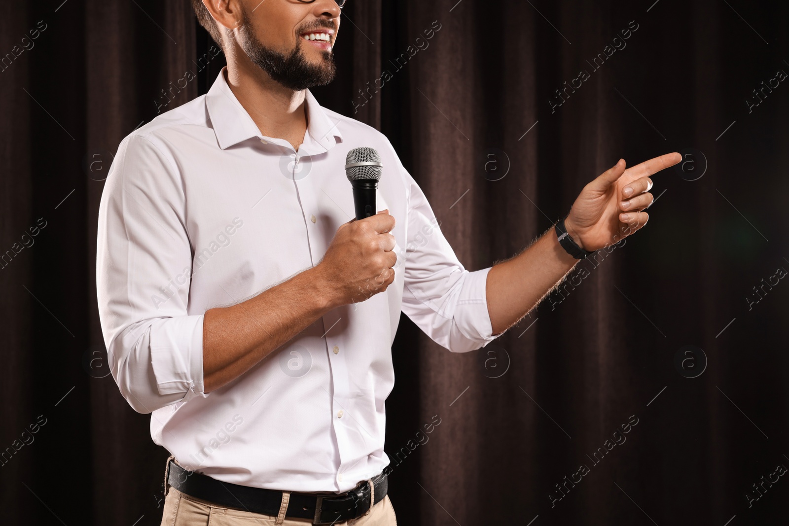 Photo of Motivational speaker with microphone performing on stage, closeup