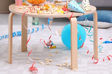 Photo of Wooden table with mess after party indoors