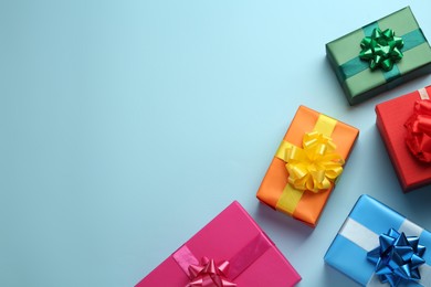 Many colorful gift boxes on light blue background, flat lay. Space for text