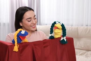 Happy woman performing puppet show at home