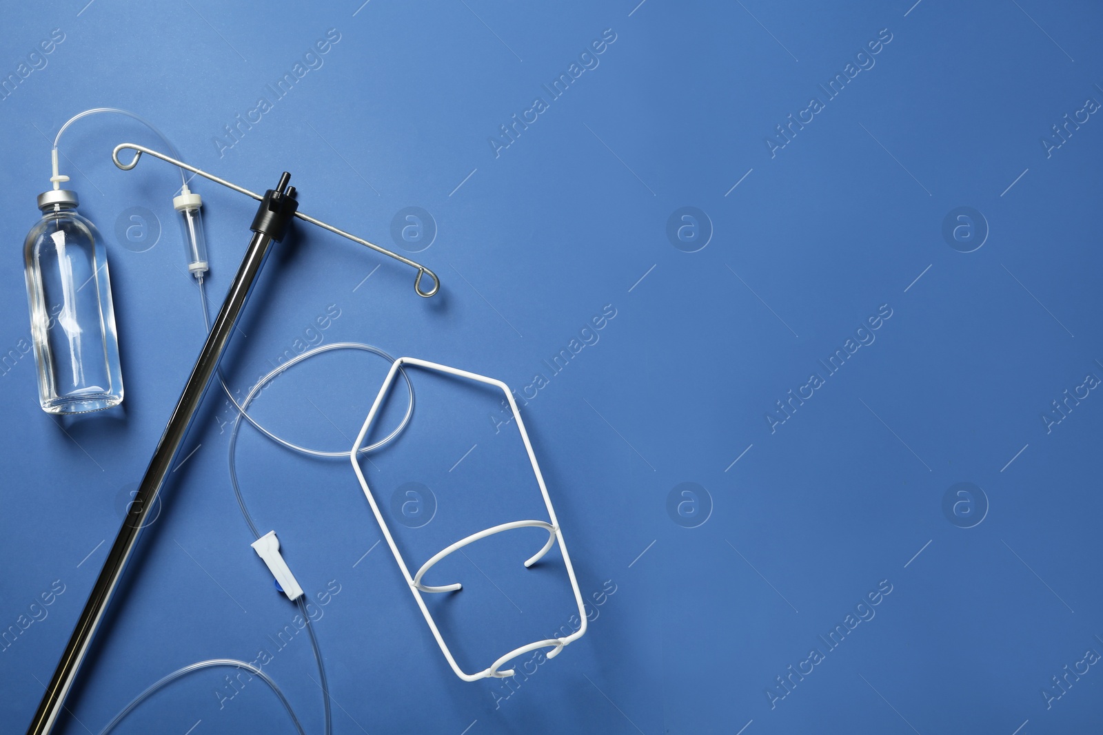 Photo of IV infusion set on blue background, flat lay. Space for text