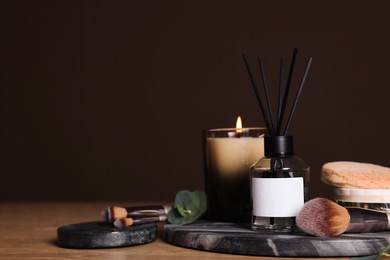 Composition with aromatic reed air freshener on wooden table, space for text