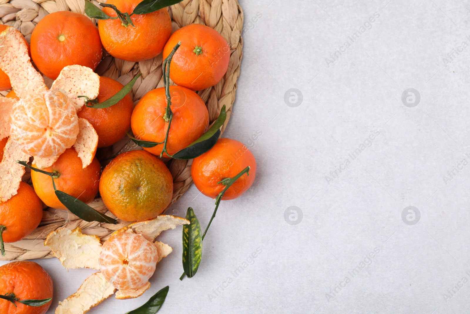 Photo of Many fresh ripe tangerines and leaves on light table, flat lay. Space for text