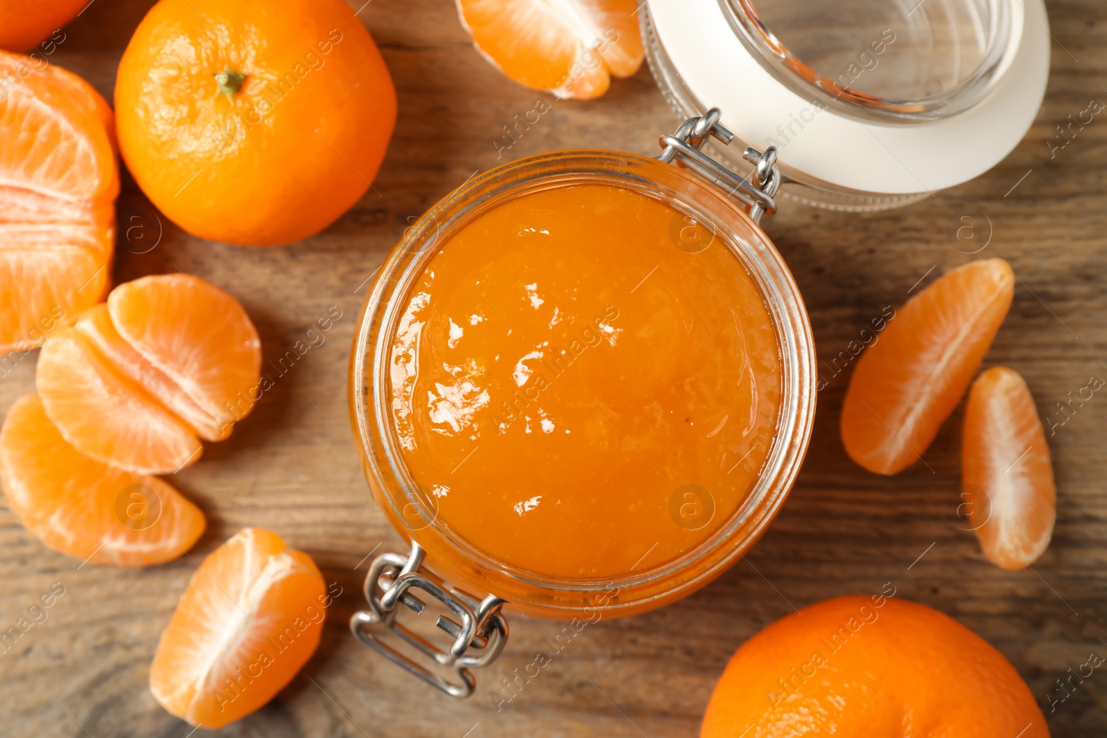 Photo of Flat lay composition with tasty tangerine jam on wooden table