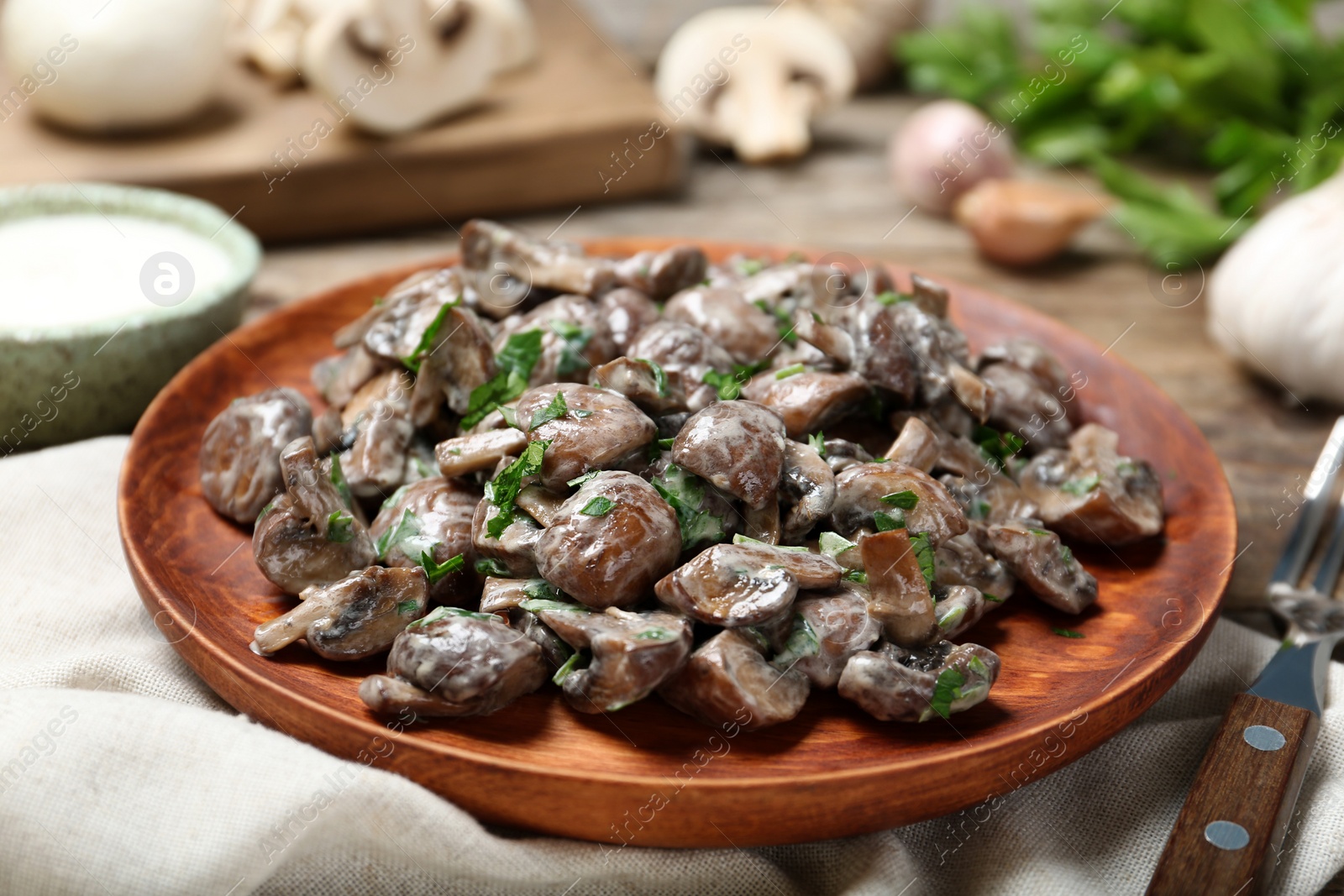 Photo of Plate of tasty fried mushrooms with sauce on table