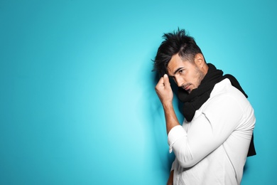 Photo of Young man with trendy hairstyle posing on color background