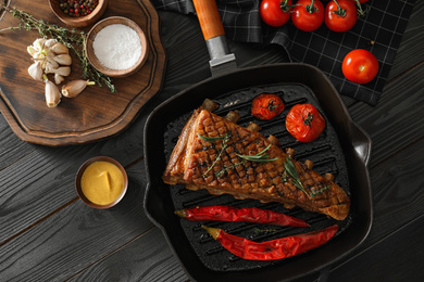 Photo of Delicious roasted ribs served on wooden table, flat lay