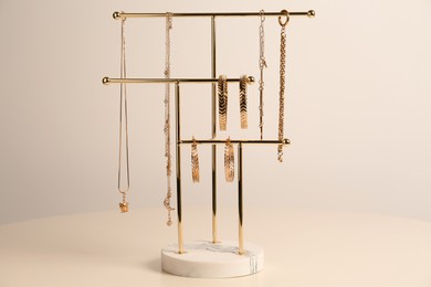 Photo of Holder with set of luxurious jewelry on white table