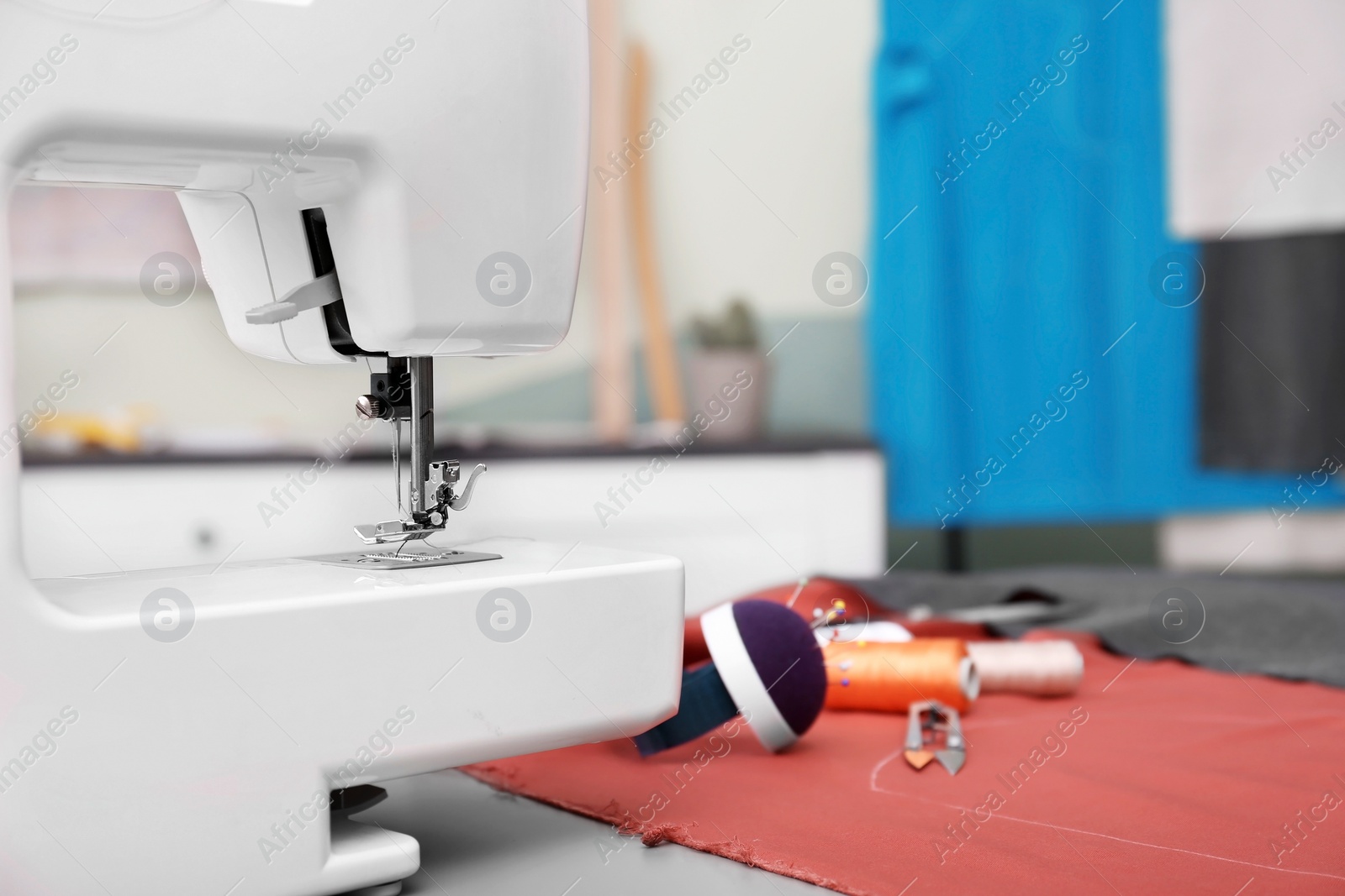 Photo of Sewing machine on table in tailor workshop, closeup