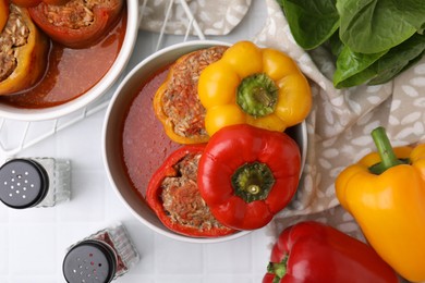 Photo of Delicious stuffed bell peppers on white tiled table, flat lay