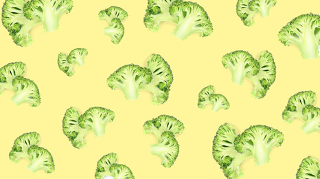 Image of Pattern of fresh green broccoli on pale light yellow background, banner design