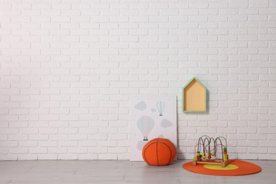 Photo of Beautiful children's room with white brick wall and toys, space for text. Interior design