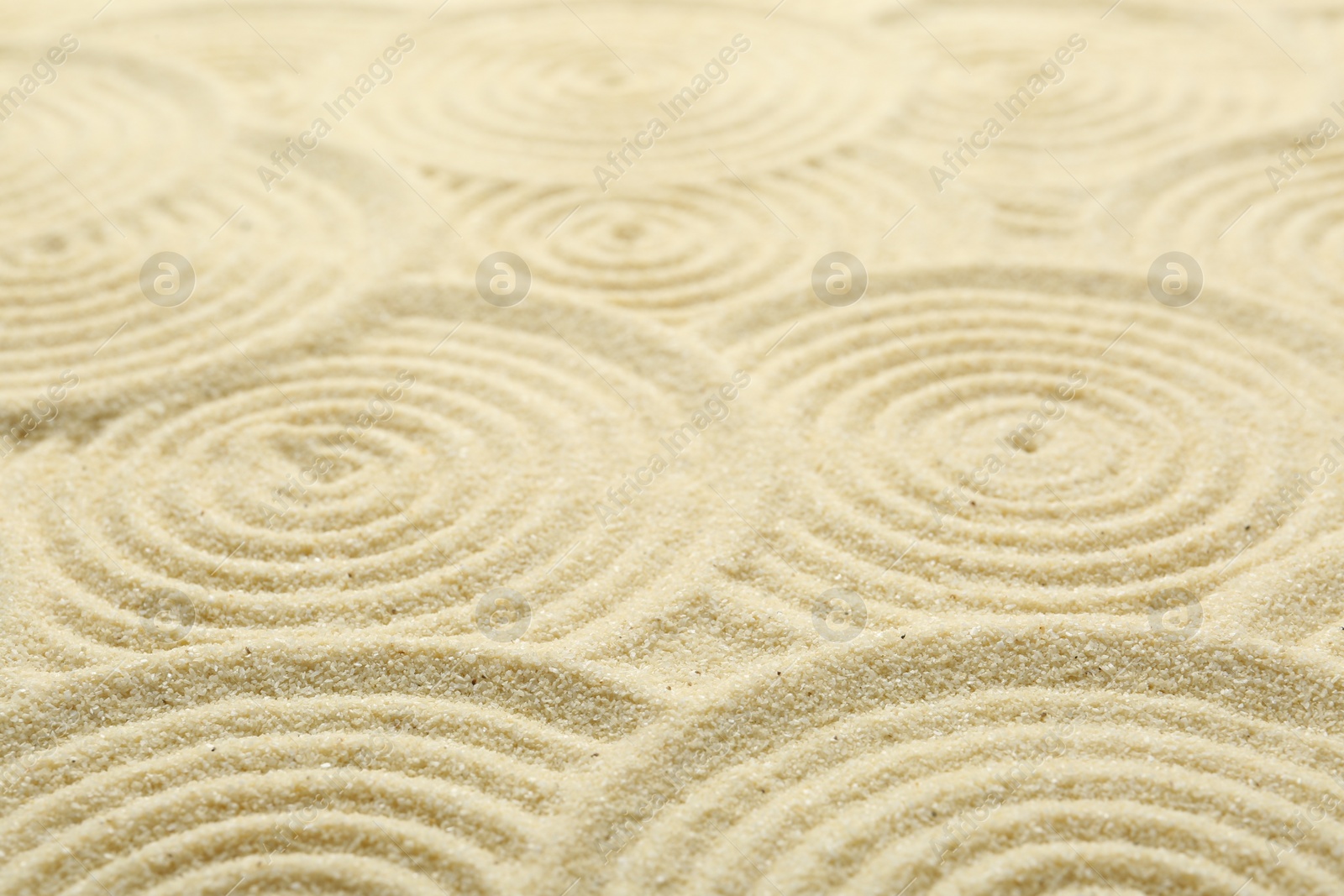 Photo of Zen rock garden. Circle patterns on beige sand