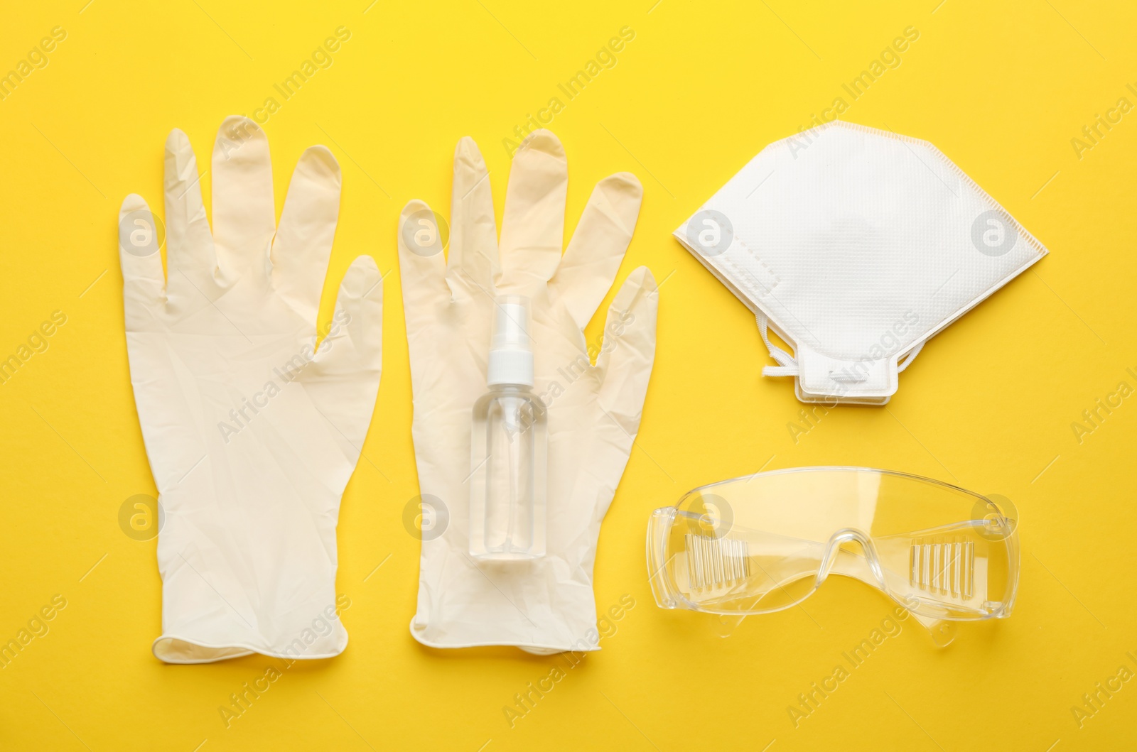 Photo of Flat lay composition with medical gloves, mask and hand sanitizer on yellow background