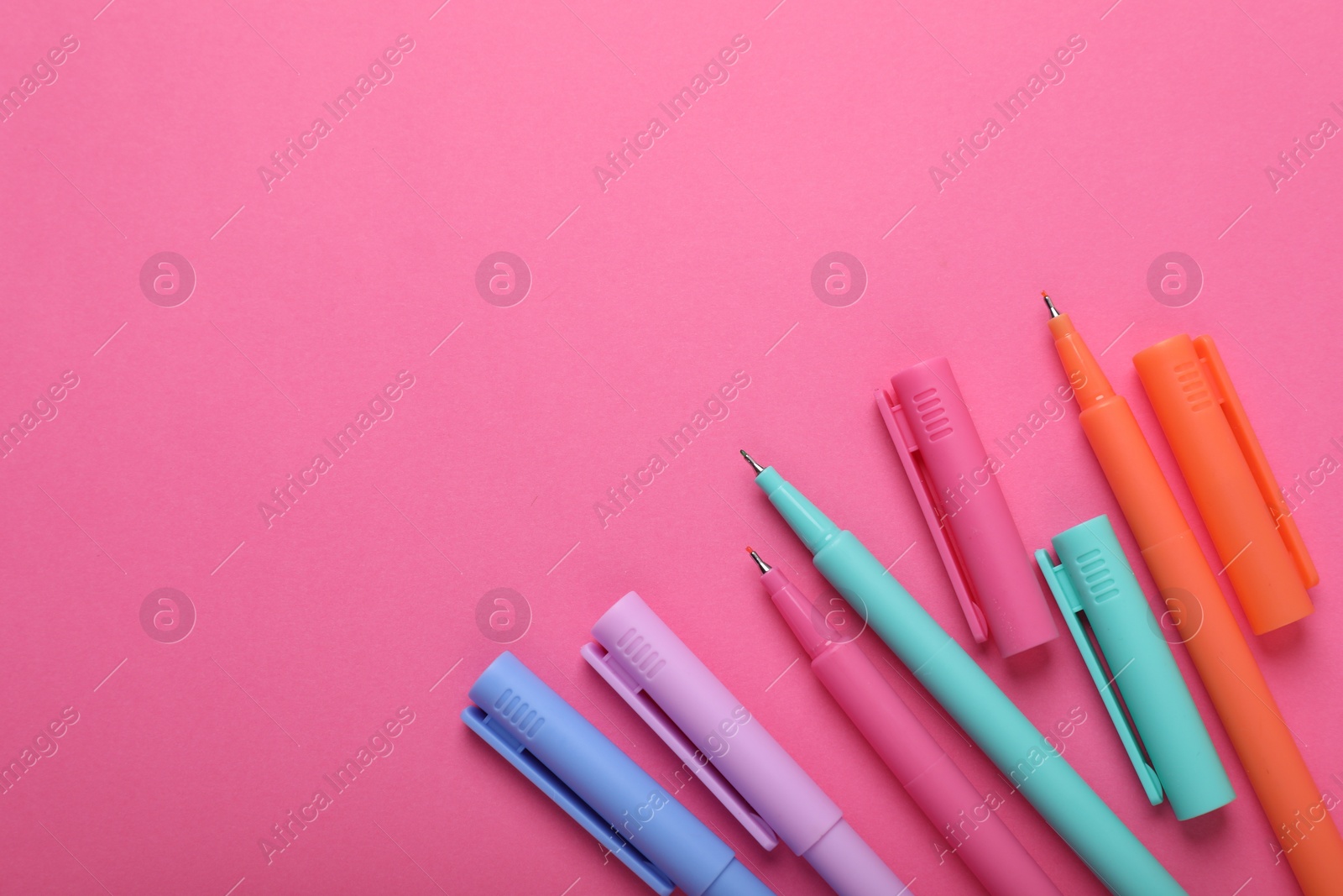 Photo of Many colorful markers on pink background, flat lay. Space for text