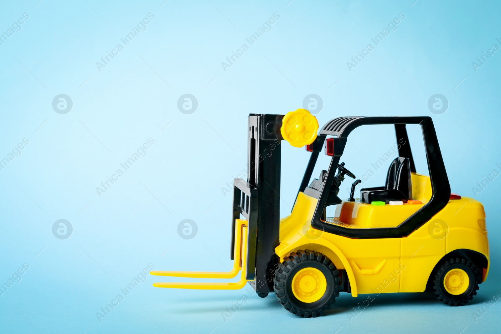 Photo of Toy forklift on blue background. Logistics and wholesale concept