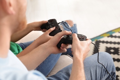 Photo of Young couple playing video games at home, closeup