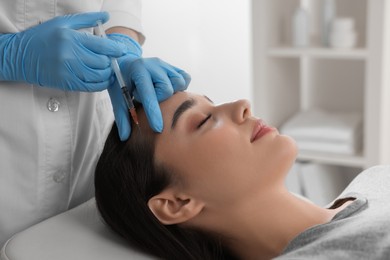 Trichologist giving injection to patient in clinic, closeup