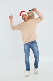 Photo of Emotional man with vintage radio on white background. Christmas music