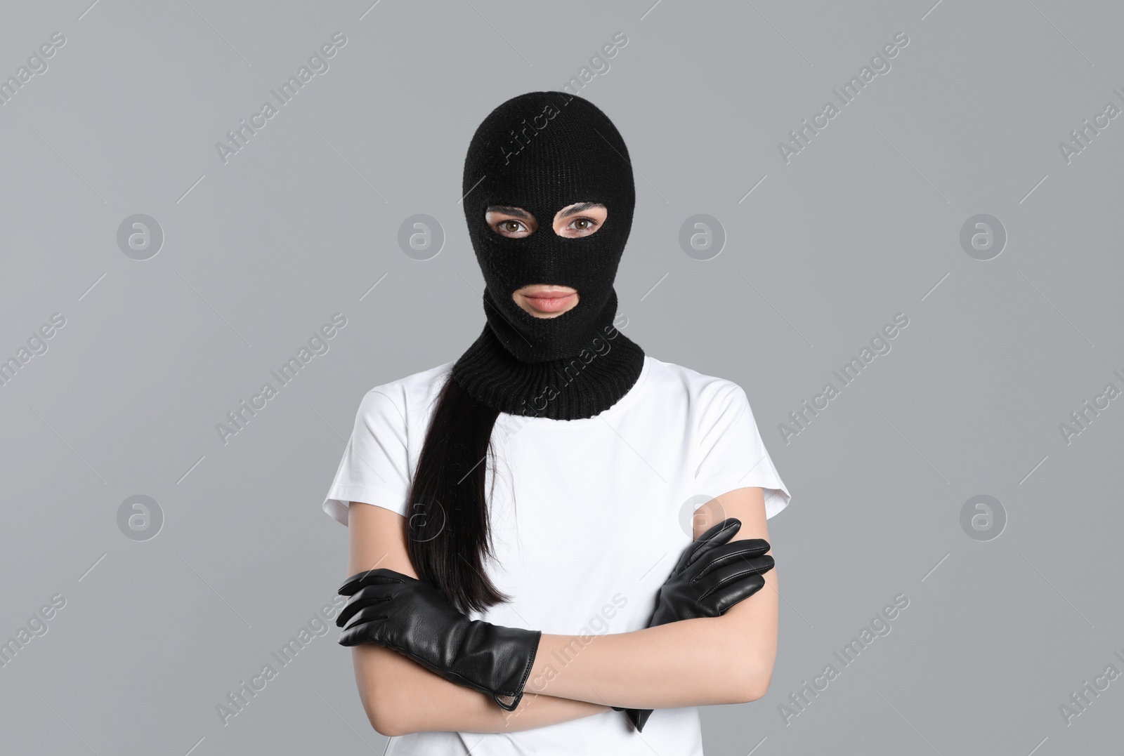 Photo of Woman wearing knitted balaclava on grey background