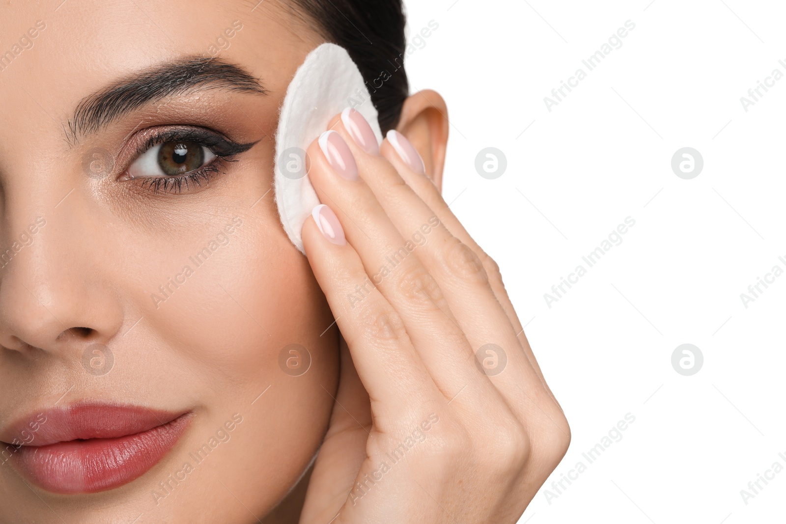 Photo of Beautiful woman removing makeup with cotton pad on white background, closeup