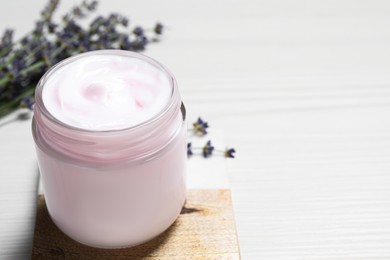 Photo of Jar of hand cream on white wooden table, space for text