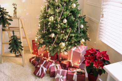 Many different gifts under Christmas tree indoors