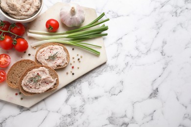 Photo of Sandwiches with delicious lard spread and vegetables on white marble table, flat lay. Space for text